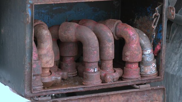 Rows of metal pipe elbows with welded joints and flanges, showcasing industrial fabrication work. Metal pipes in the form of a half-branch.
