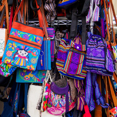 Obraz premium Fabric bags for sale at a roadside mall in Santa Fe, NM, with bold floral and other embroidered designs