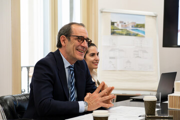 Fototapeta premium Business professionals discussing project blueprints and models in a modern office