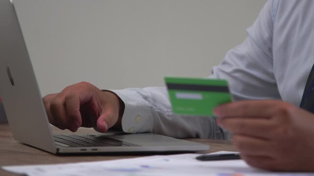 Office Worker Completing a Secure Online Transaction with a Laptop and Credit Card, Highlighting Cashless Payments and Modern E-Commerce