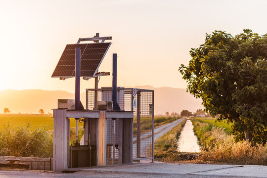Solar powered irrigation station near Ebro Delta rice fields at sunset, Catalonia, Spain