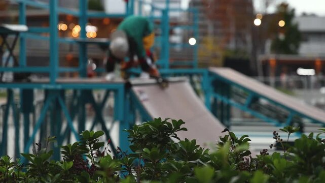 Skate park with kids on a kick scooter doing tricks and stunts, boys and girls in a skate park riding bmx bike and skate, playing and enjoying summer on new ramp, teenagers skateboarders and riders 