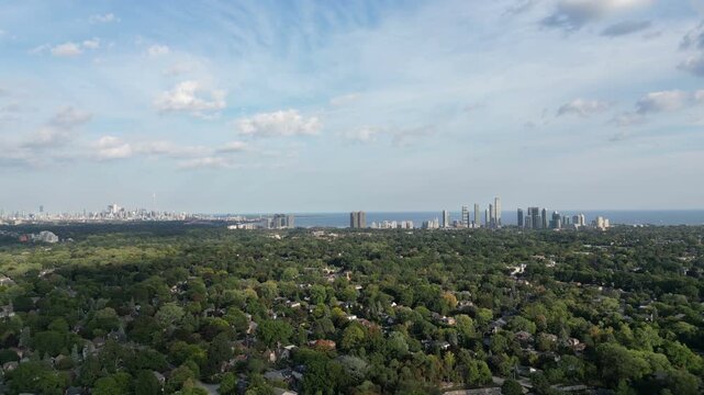 Aerial over Bloor Street West Islington, over the Kingsway neighborhood of Toronto, Ontario, Canada. Flying southeast with the downtown core Toronto skyline, Mimico and Lake Ontario in the distance. 