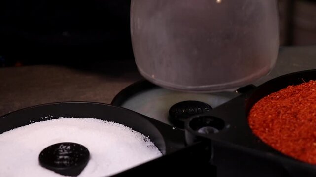 Preparing a Salt and Chili Rim on a Chilled Round Glass Mug. Preparing a Mexican-Style Rimmed Glass. Close Up of Glass Rimming with Lime, Salt and Chili. Cold Round Mug Being Prepared for Michelada