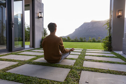 Concrete pavers forming grass grid on patio and leading toward sunlit mountain ridge