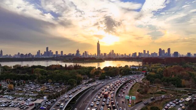 Nanjing skyline over Xuanwu Lake at sunset with busy highway traffic in Nanjing, Jiangsu, China