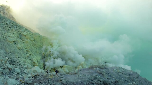 Sulfur miners in dense volcanic steam at Ijen Crater, East Java, Indonesia