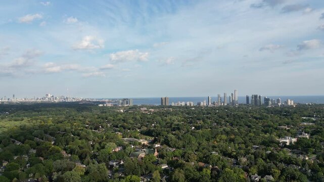 Aerial over Bloor Street West from Islington, the Kingsway neighborhood of Toronto, Ontario, Canada. The downtown core Toronto skyline, Mimico and Lake Ontario in the distance. 