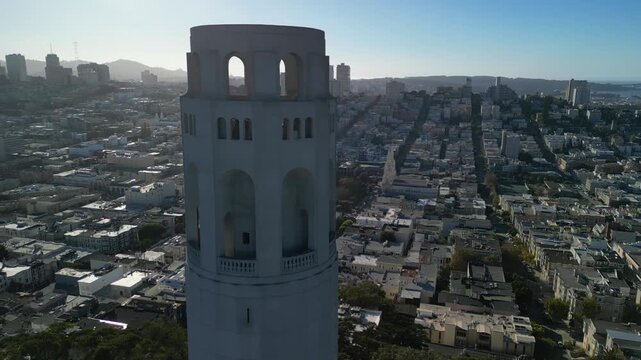 Aerial drone footage of Coit Tower in San Francisco, California, captured from above with stunning panoramic views of the city skyline, Telegraph Hill, the San Francisco Bay, and surrounding urban