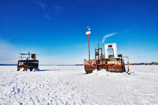 two industrial water intake structures (often referred to as intake cribs or pump towers) standing out of the completely frozen surface of Lake Champlain, Burlington, Vermont