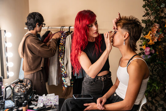 Makeup artist applying eyeliner during fashion photoshoot