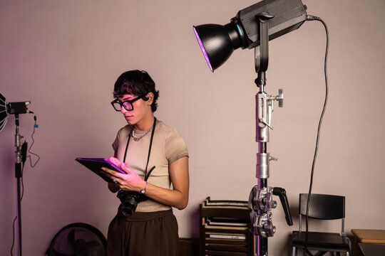Photographer reviewing images on tablet in studio lighting