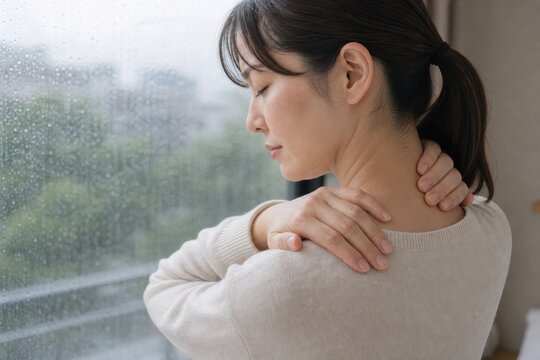 肩を押さえる女性の低気圧による首肩不調