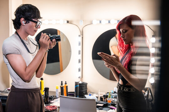 Behind the scenes photographer and makeup artist at mirror