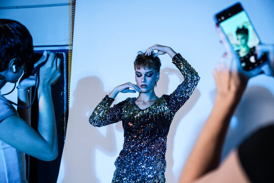 Fashion model pose during studio photo shoot in blue light