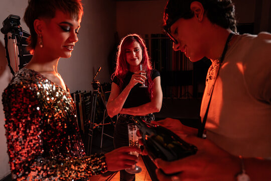 Fashion photoshoot crew celebrating on set with champagne