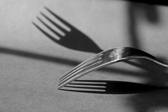 Close-up Stainless Steel Fork with Dramatic Shadow. Minimalist Dining Concept.