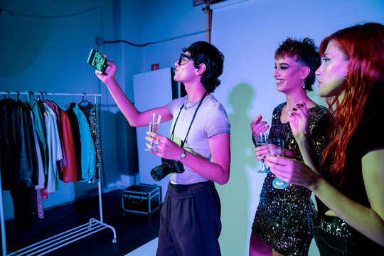 Fashion shoot crew celebrating backstage with selfie