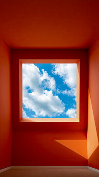 Sky view through square window in orange minimal room