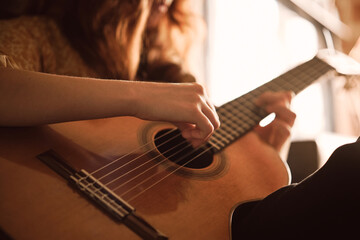 Fototapeta premium guitar, acoustic, music, hands, playing, cinematic, artistic, strings, musician, closeup, warm, golden, light, creative, performance, instrument, fretboard, melody, song, artist, passion, sound