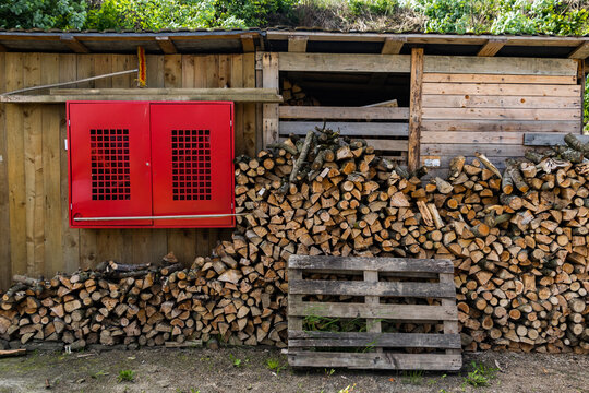 Firewood shed with red safety cabinet
