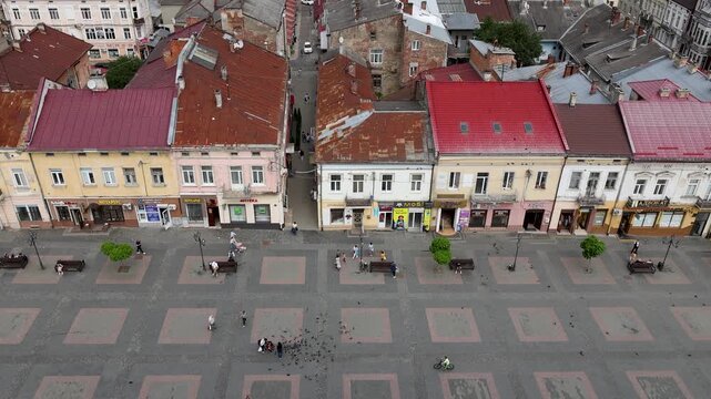 High angle stationary shot from the city hall tower overlooking historic colorful buildings and the pedestrian Rynok Square plaza in the old town of Drohobych, Ukraine.