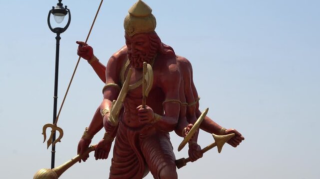Mythological Ravana Statue with Weapons and Crown Against Blue Sky