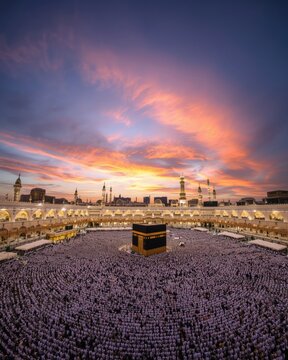 Aerial view of the grand mosque in mecca with thousands of pilgrims circling the kaaba during a vibrant sunset