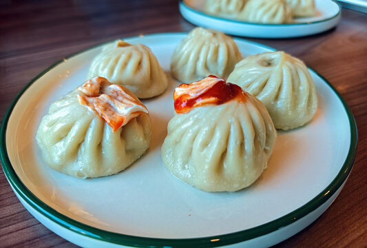 These dishes are called buuz (or pozy) and are a traditional dish of Buryat and Mongolian cuisine. They are steamed and filled with a juicy mixture of ground beef and pork seasoned with onions.