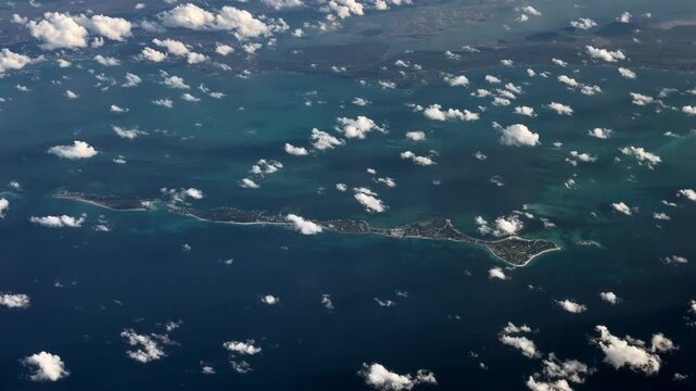 4k aerial video footage flying across The Bahamas, with Great Guana Cay and Scotland Cay  as part of Abaco Island, surrounded by shallow turquoise water surface, located in the Caribbean Sea