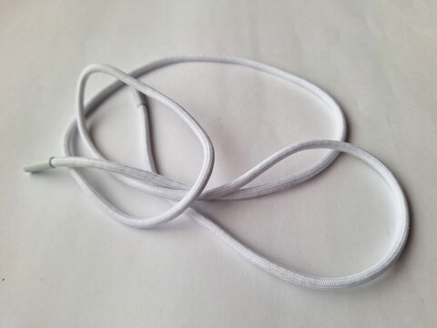 White round shoelace with plastic tips on light background