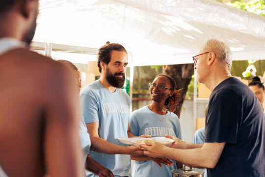 Members of a multicultural community come together, volunteering at non-profit center to donate food and essentials to the homeless and underprivileged. Young volunteers helping the poor and needy.