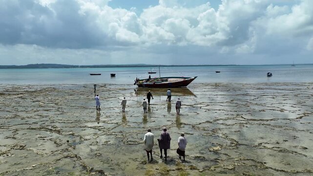 Local Community Walking Toward a Stranded Boat at Low Tide, January 21, 2025, Tumbatu Island, Zanzibar, Tanzania