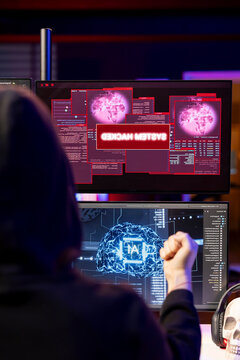 Hacker receiving system hacked message after attacking PCs using AI malware software while rogue software developer in secret lair trying to hide online activity after stealing data.