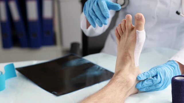 Traumatologist looks at x-ray of patient legs and sore leg examine.