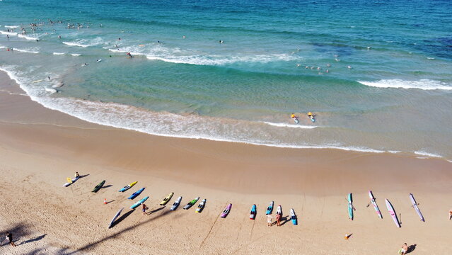 Australian surf life savers training next to tourists on a beach in summer	