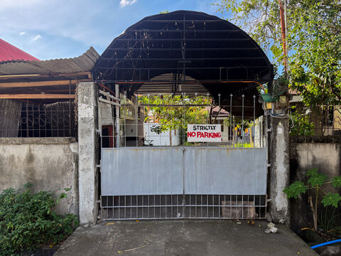 No parking sign on residential driveway gate in Dumaguete