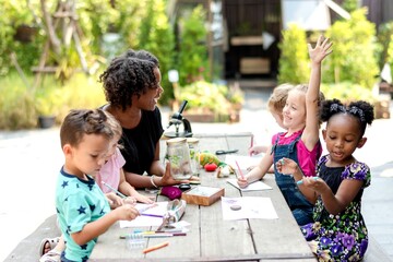 Obraz premium Diverse group of children and a teacher engaged in outdoor learning.