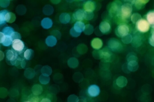 Abstract green bokeh lights creating a vibrant natural background with soft glowing orbs