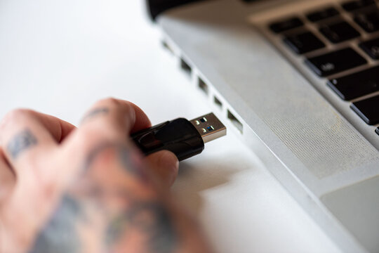 Hand inserting USB drive laptop