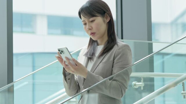 携帯を見て悩む女性