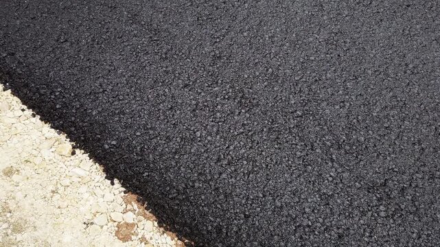 Road construction. Fresh layer of asphalt. Rainy weather. Abstract close up shot