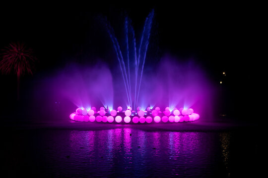 Magenta lights at water fountain winter event