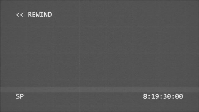 VHS rewind screen with analog noise and timecode counter on a dark grainy video background