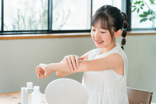 Children, girls, elementary school students, and junior high school students applying sunscreen, skincare, body care, and hand cream.