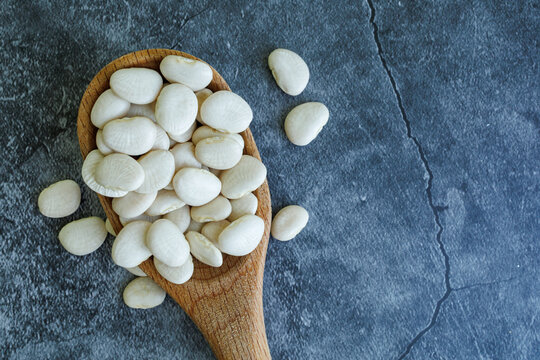 Lima beans on wooden spoon.