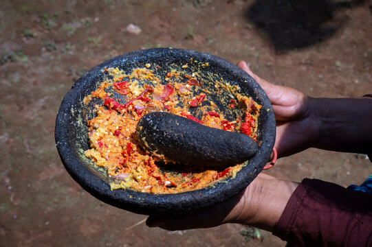 Hands Holding Stone Mortar With Fresh Red Chili Sambal