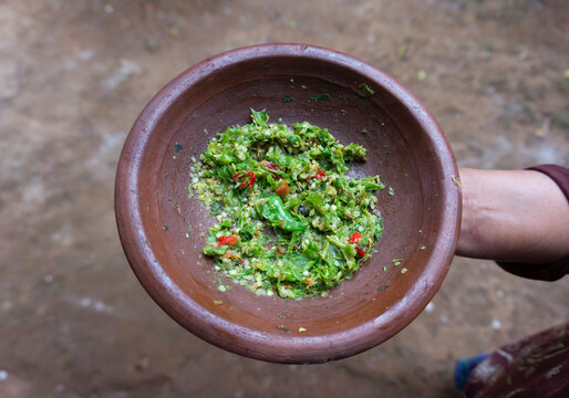 Hand Holding Traditional Mortar With Fresh Green Chili Sambal