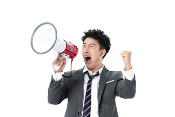 Excited businessman shouting through megaphone with raised fist