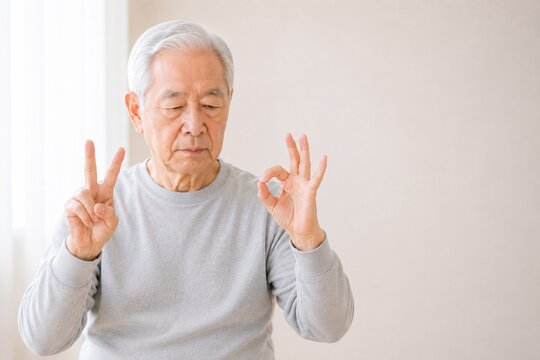 Senior Japanese man doing finger coordination exercise for frailty prevention, mid shot